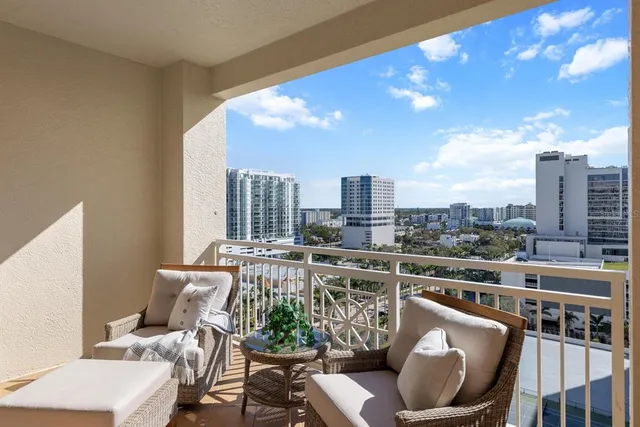a living room with furniture a chandelier and a potted plant