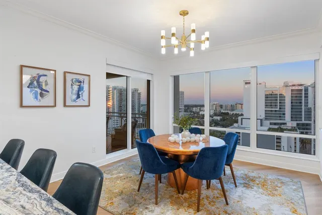 a living room with patio furniture and a chandelier