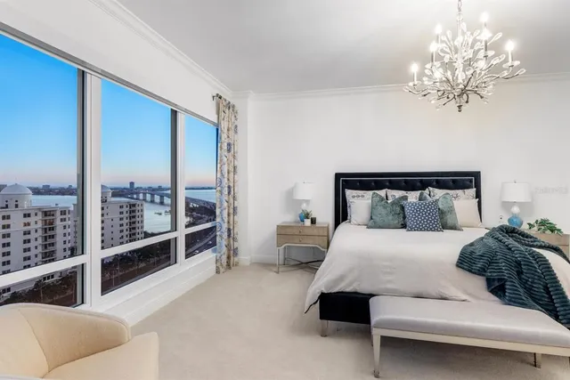 a view of a patio with a table and chairs under an umbrella with a barbeque