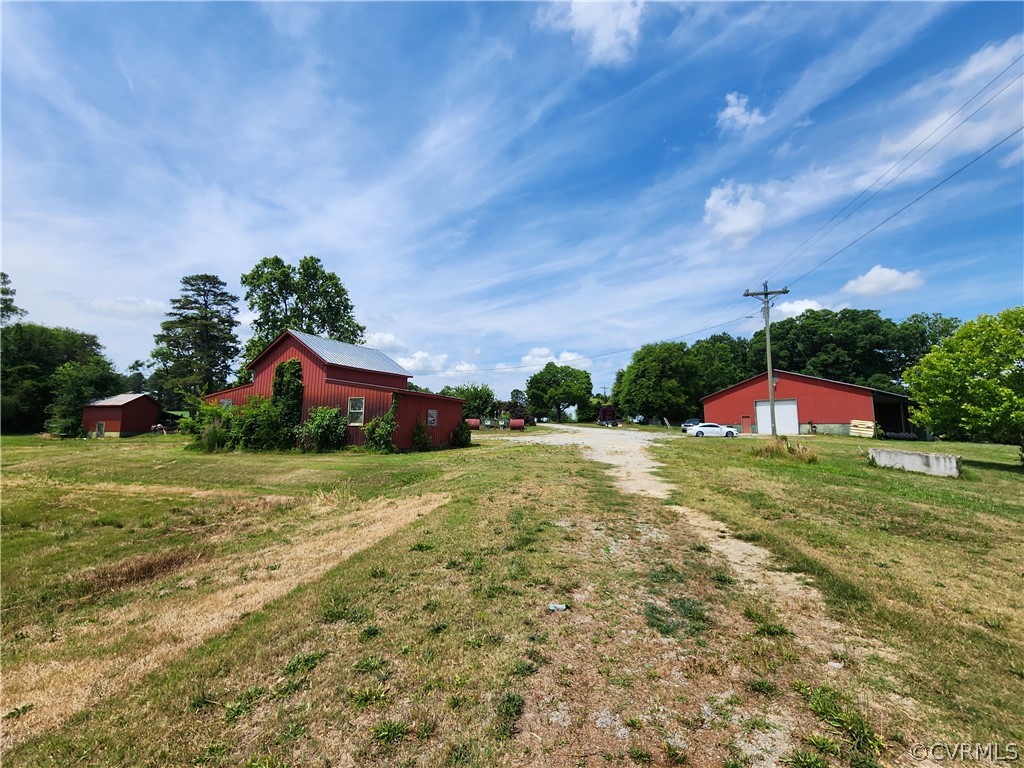 9360 Buggs Island Road Baskerville, VA 23915 - Photo 1 of 1 a yellow and red umbrella sitting in the middle of a field