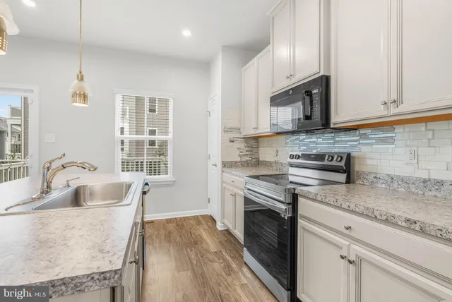 a kitchen with stainless steel appliances granite countertop a sink stove and cabinets