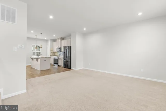 a view of a kitchen with refrigerator and a sink