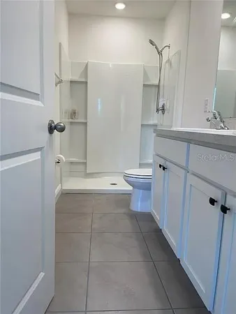 a bathroom with a sink a toilet and shower