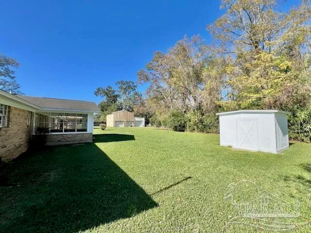 a view of a house with backyard and a tree