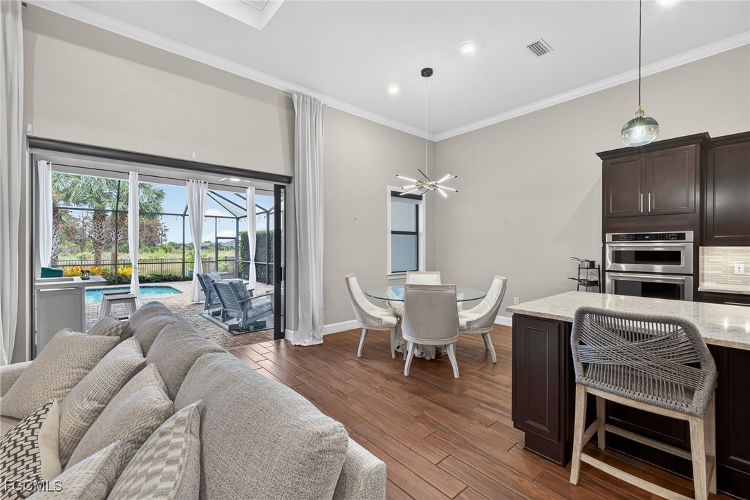19815 Beverly Park Road Estero, FL 33928 - Photo 15 of 49 a living room with furniture a flat screen tv and a floor to ceiling window