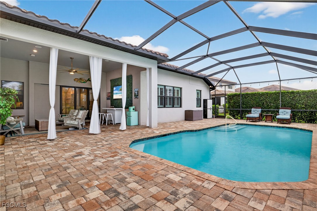 19815 Beverly Park Road Estero, FL 33928 - Photo 32 of 49 a view of a patio with a table and chairs under an umbrella