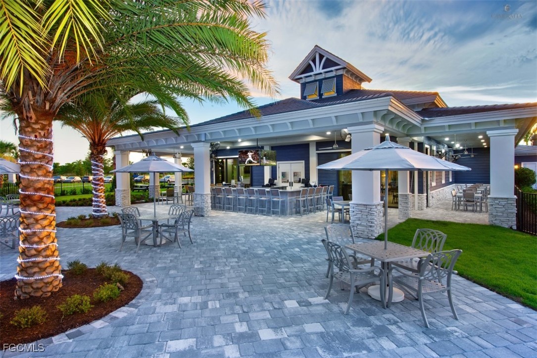 19815 Beverly Park Road Estero, FL 33928 - Photo 39 of 49 a view of a patio with a table and chairs under an umbrella