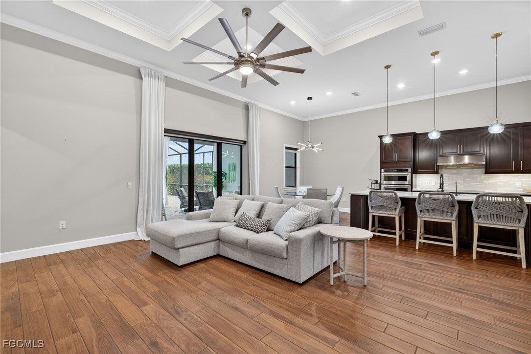 19815 Beverly Park Road Estero, FL 33928 - Photo 4 of 49 a living room with furniture kitchen area and a wooden floor