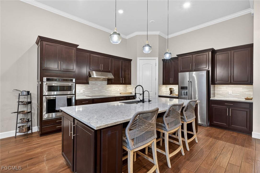 19815 Beverly Park Road Estero, FL 33928 - Photo 9 of 49 a kitchen with kitchen island granite countertop wooden cabinets and stainless steel appliances