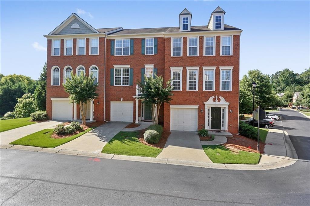 1003 Renaissance Trace Roswell, GA 30075 - Photo 1 of 1 a front view of a residential apartment building with a yard and potted plants