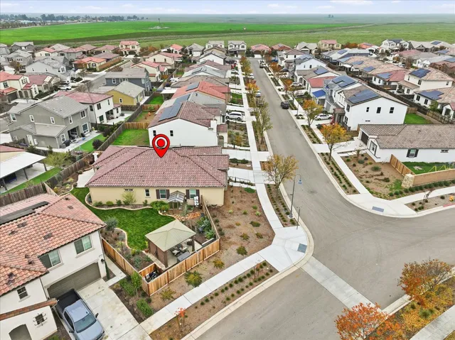 an aerial view of residential houses with outdoor space and parking