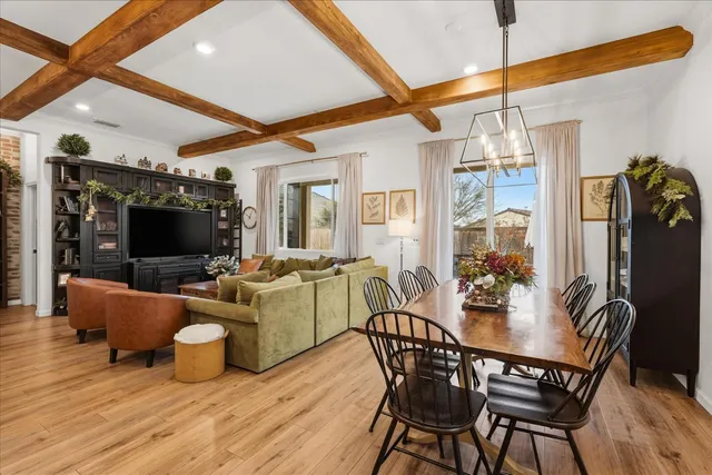 a dining room with furniture a potted plant and wooden floor
