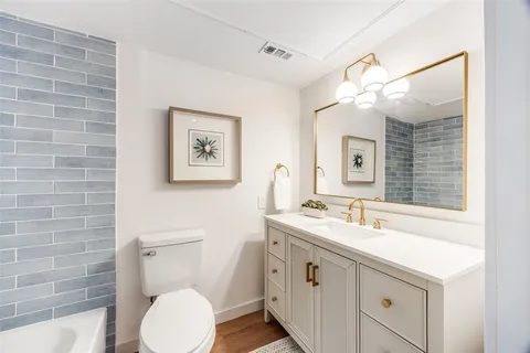 a bathroom with a sink mirror vanity and toilet