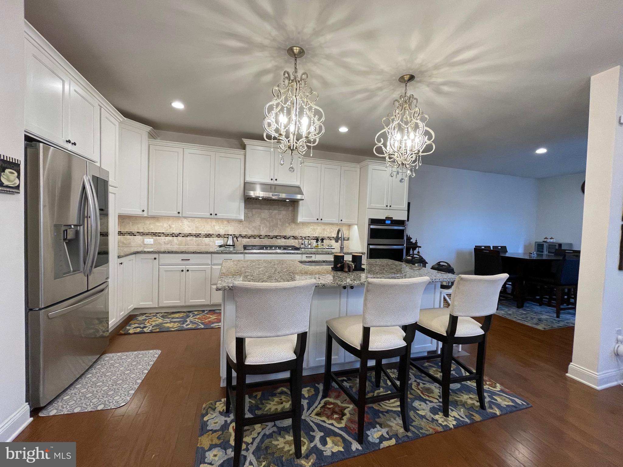 17 Peacock Way Princeton, NJ 08540 - Photo 12 of 44 a kitchen with stainless steel appliances granite countertop a dining table chairs and a refrigerator