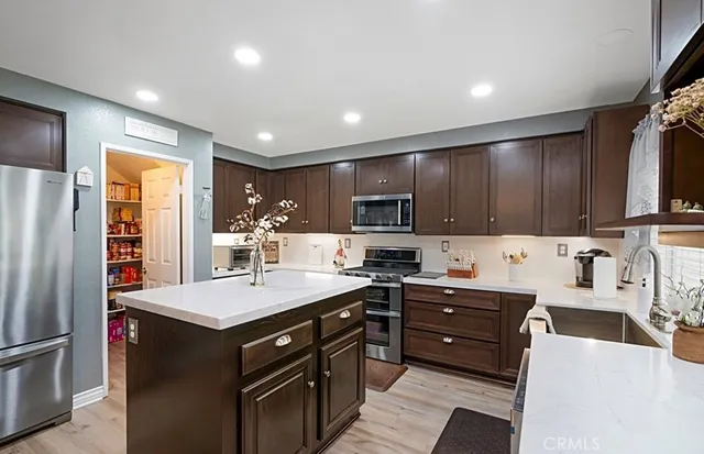 a kitchen with stainless steel appliances a sink stove refrigerator and cabinets