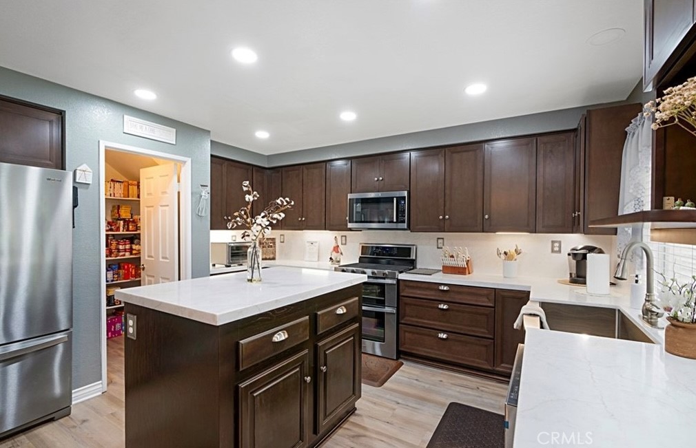 14903 Manor Court Chino Hills, CA 91709 - Photo 5 of 15 a kitchen with stainless steel appliances a sink stove refrigerator and cabinets