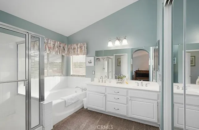 a bathroom with a tub a sink and mirror