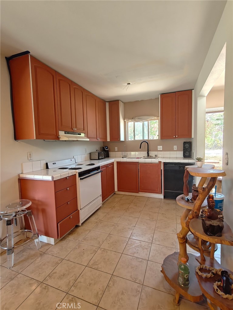 49438 Conejo Road Morongo Valley, CA 92256 - Photo 5 of 18 a kitchen with stainless steel appliances granite countertop a stove sink and cabinets