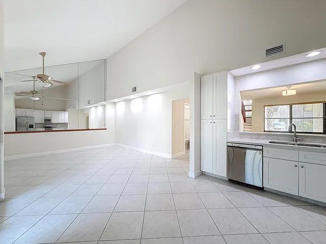 an empty room with fan and windows