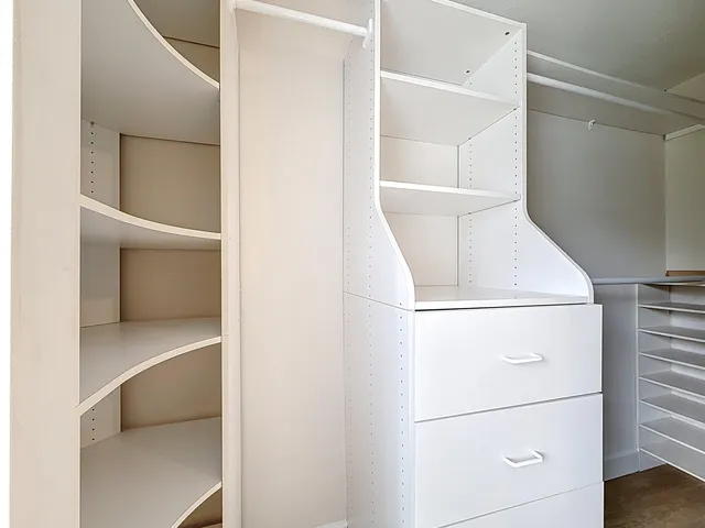a view of walk in closet with empty racks