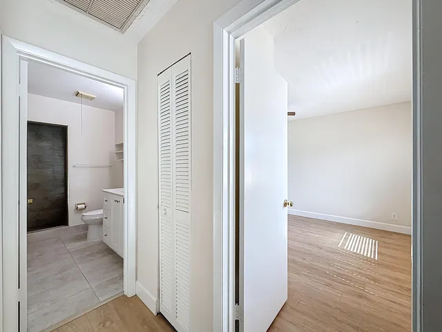 an empty room with wooden floor and ceiling fan