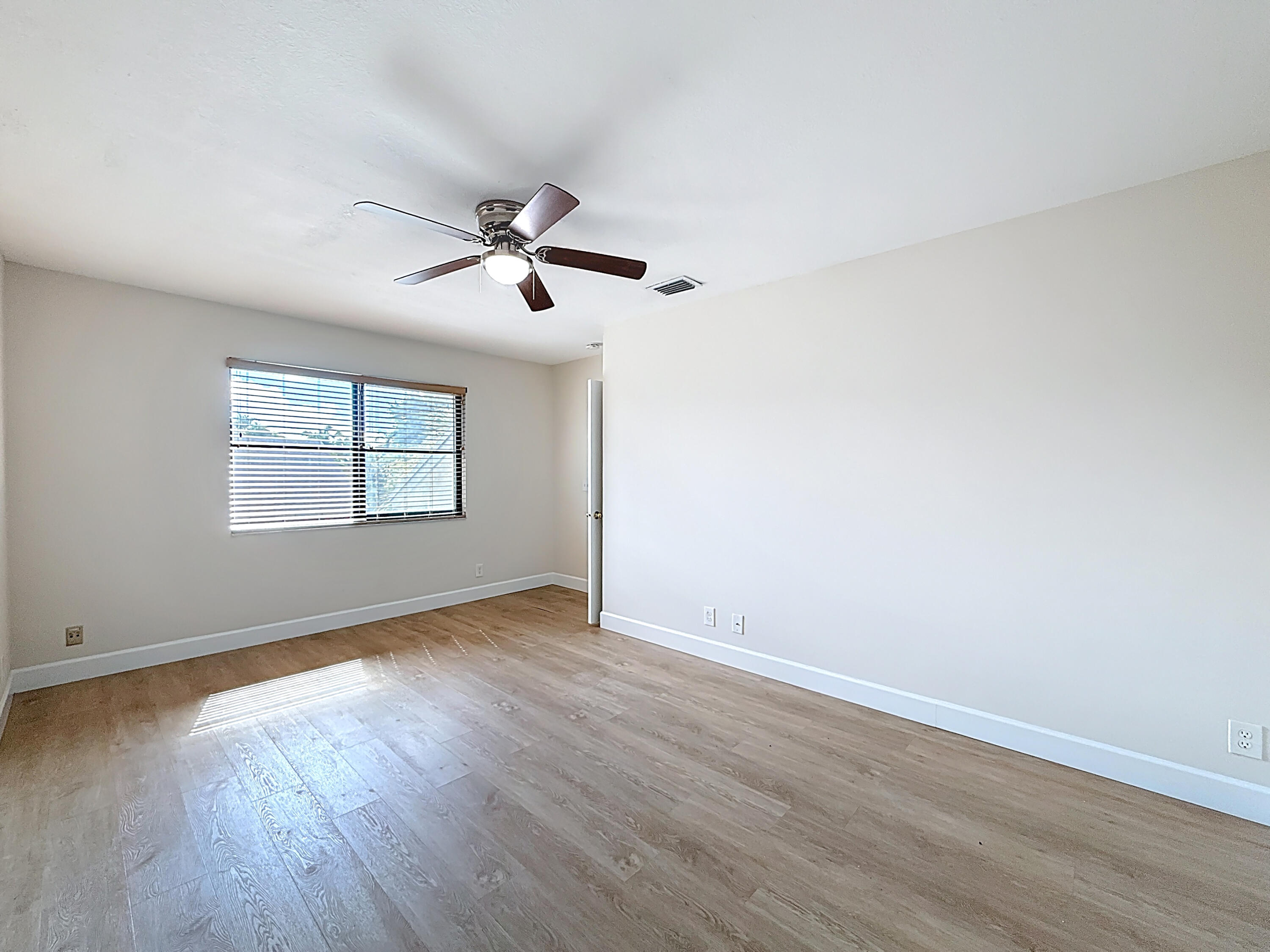 9278 Ketay Circle Boca Raton, FL 33428 - Photo 32 of 55 an empty room with wooden floor ceiling fan and windows