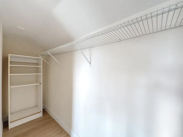 a view of walk in closet with empty racks