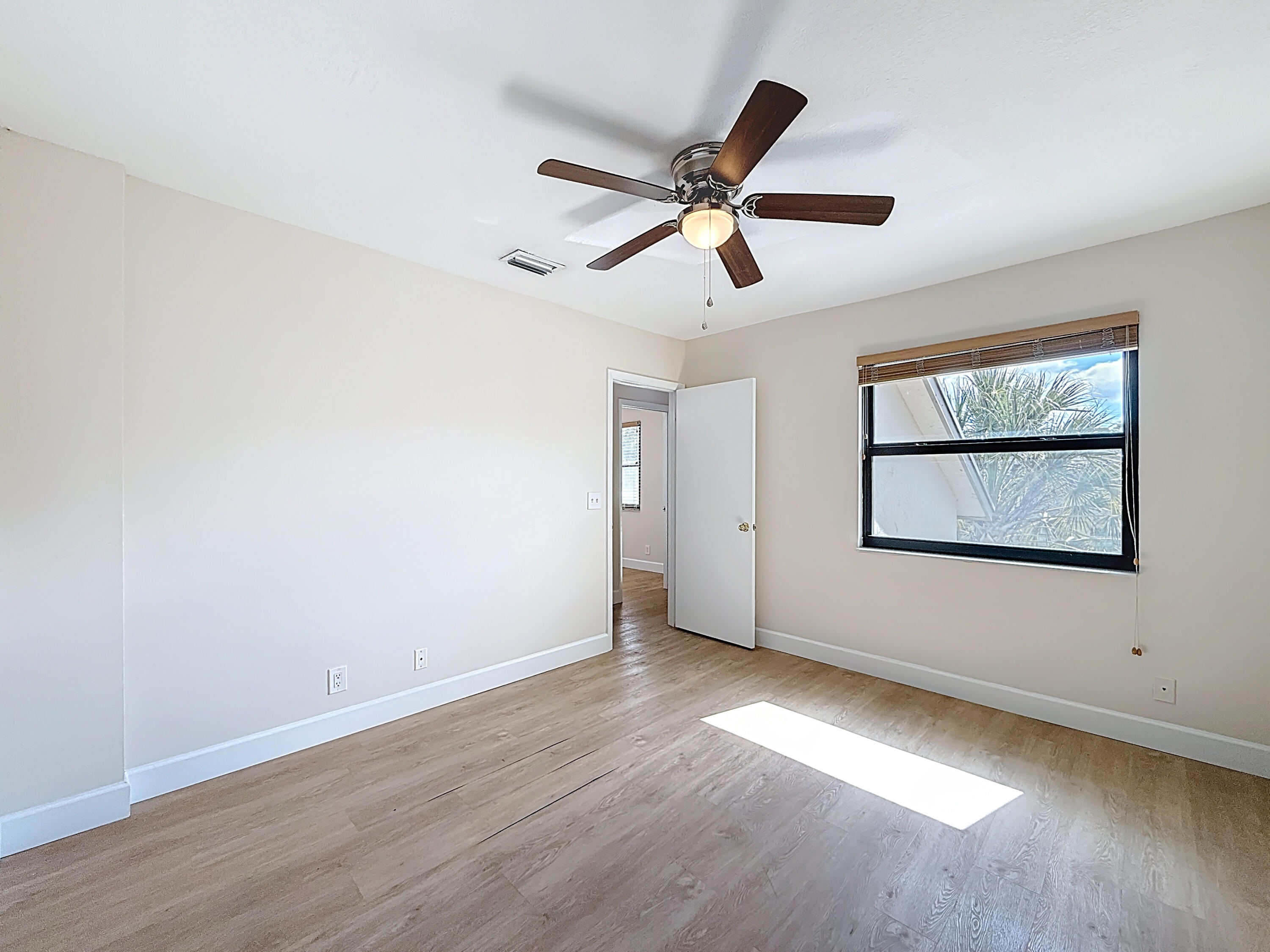 9278 Ketay Circle Boca Raton, FL 33428 - Photo 39 of 55 an empty room with wooden floor ceiling fan and windows
