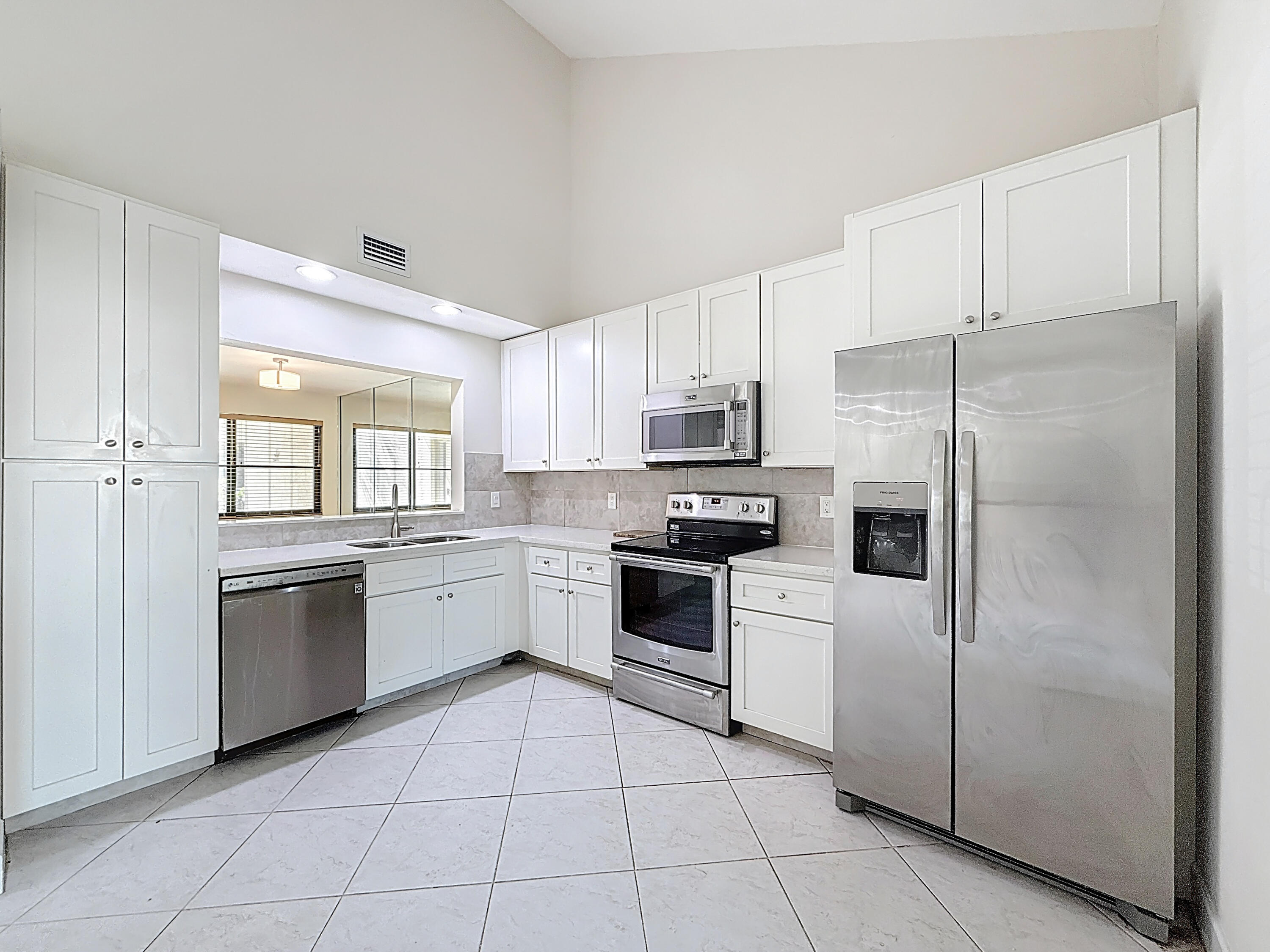 9278 Ketay Circle Boca Raton, FL 33428 - Photo 9 of 55 a kitchen with white cabinets stainless steel appliances and a window