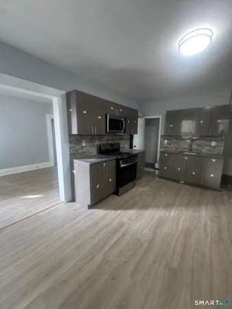 a large kitchen with cabinets wooden floor and stainless steel appliances