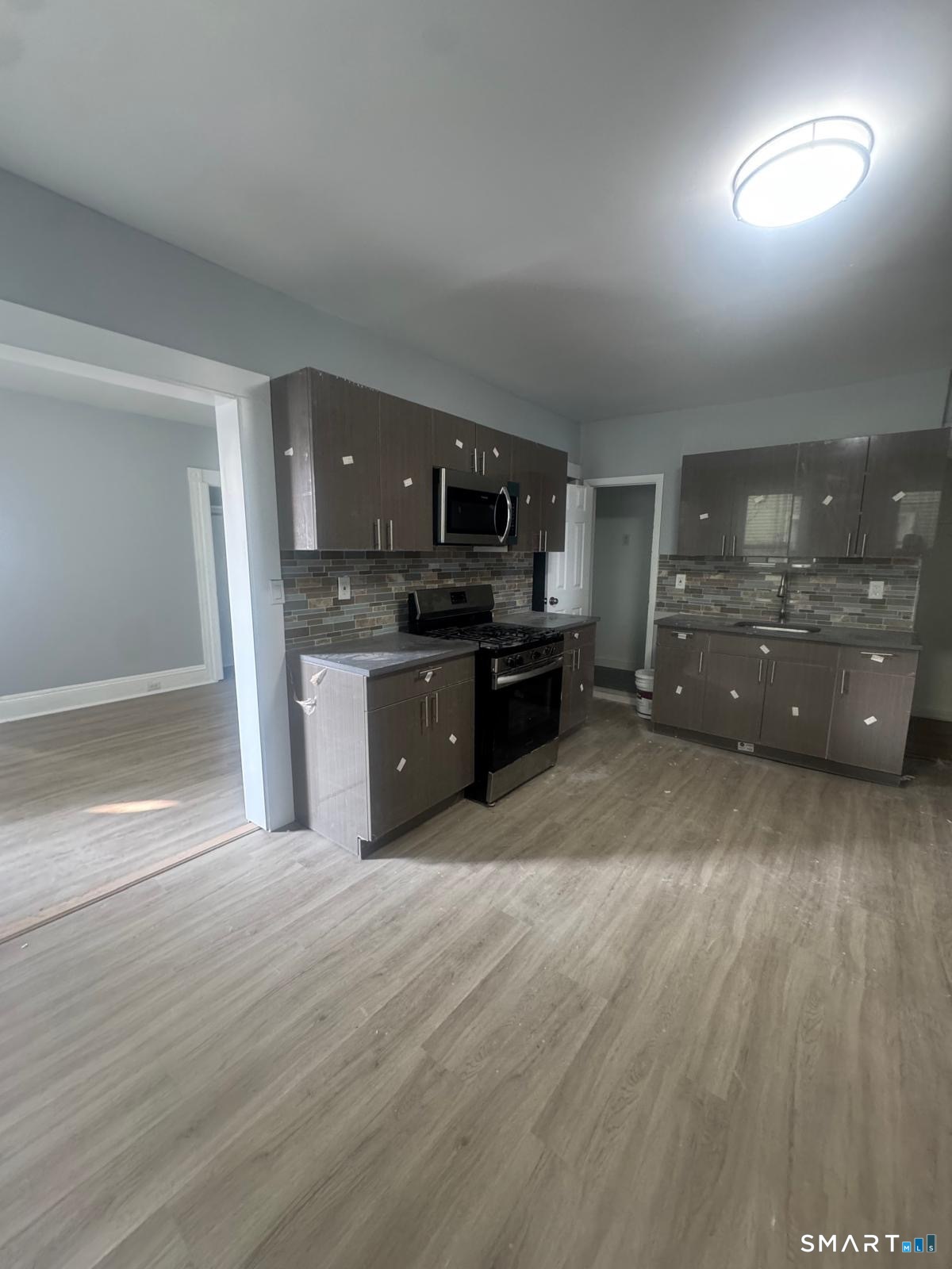 a large kitchen with cabinets wooden floor and stainless steel appliances