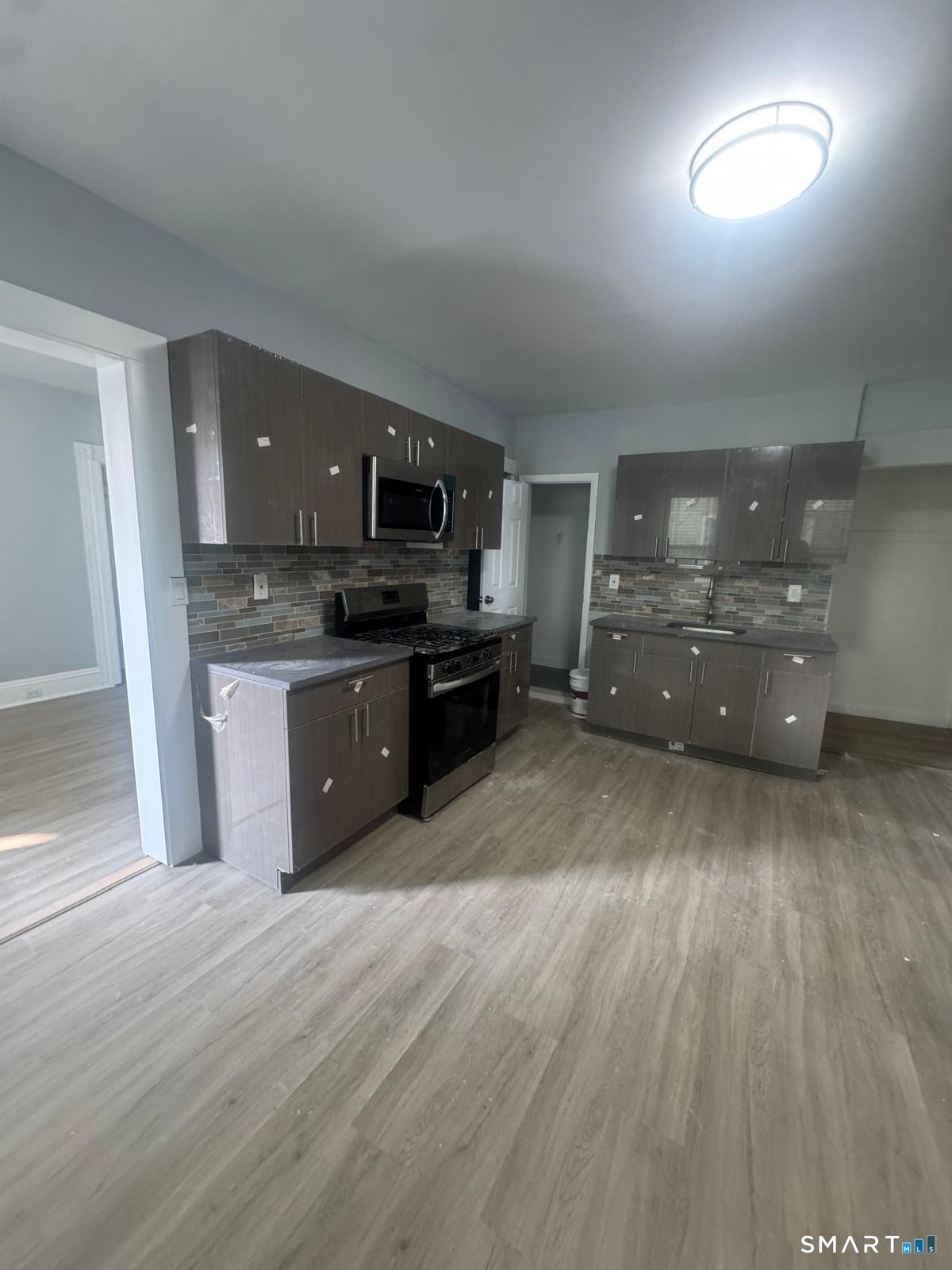 105 Caroline Street, Unit 2 Bridgeport, CT 06608 - Photo 2 of 6 a large kitchen with wooden floors and stainless steel appliances