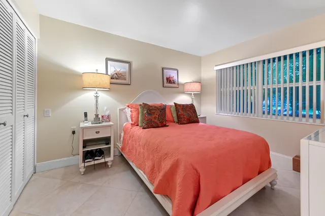 a bedroom with a large bed and a flat tv screen on dresser