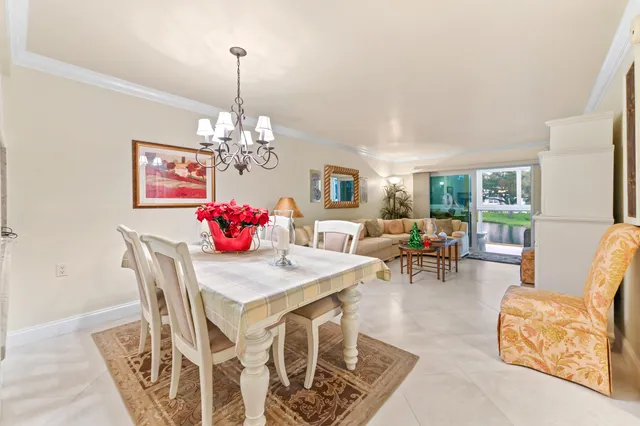 a dining room with furniture a chandelier and window