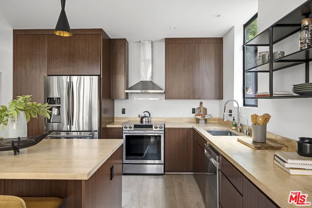 a kitchen with stainless steel appliances granite countertop a sink and a refrigerator
