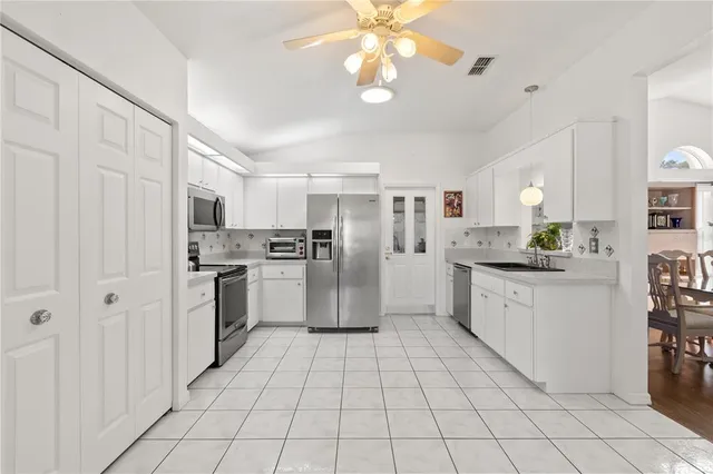 a kitchen with white cabinets and stainless steel appliances