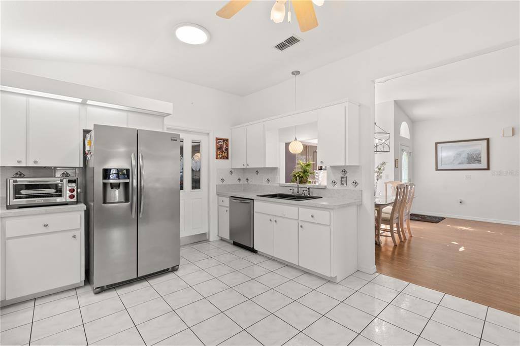 11287 Southwest 73rd Circle Ocala, FL 34476 - Photo 12 of 37 a kitchen with granite countertop cabinets a refrigerator and a sink