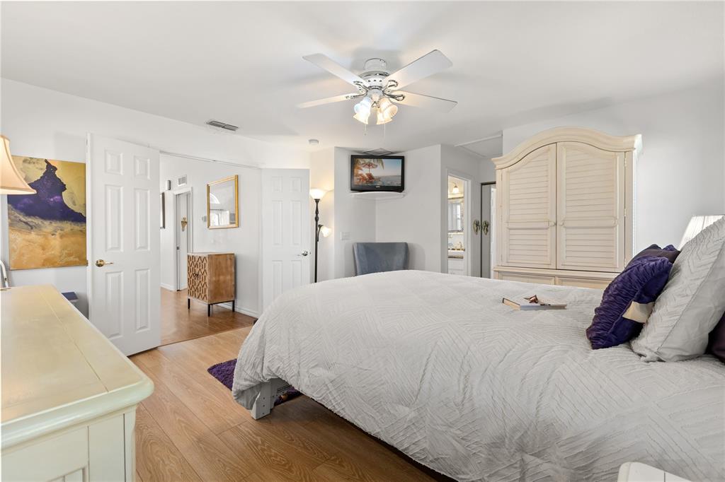 11287 Southwest 73rd Circle Ocala, FL 34476 - Photo 16 of 37 a bedroom with a large bed and a chandelier