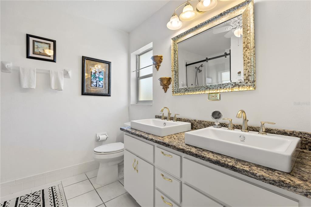 11287 Southwest 73rd Circle Ocala, FL 34476 - Photo 20 of 37 a bathroom with a granite countertop toilet sink and mirror