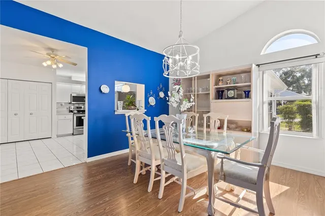 a view of a dining room with furniture a chandelier and wooden floor