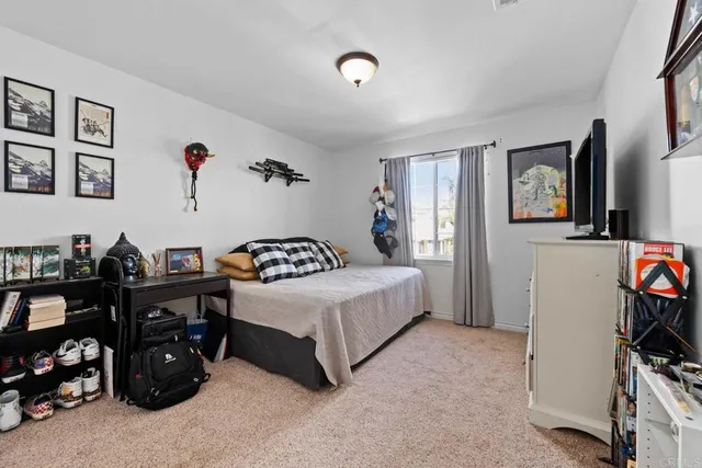 a bedroom with a bed furniture and a flat tv screen