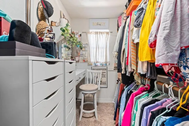 a view of walk in closet with clothes