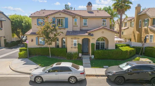 a car parked in front of a house with a yard