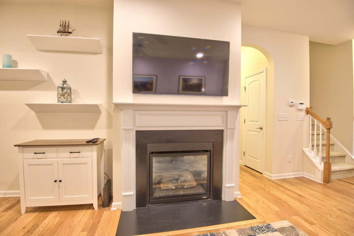 Undisclosed Address Durham, NC 27705 - Photo 11 of 25 a living room with a fireplace and a wooden floor