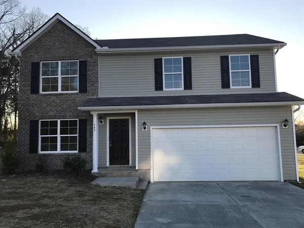 a front view of a house with a yard and garage