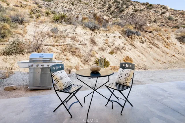 a view of a backyard with table and chairs and iron fence