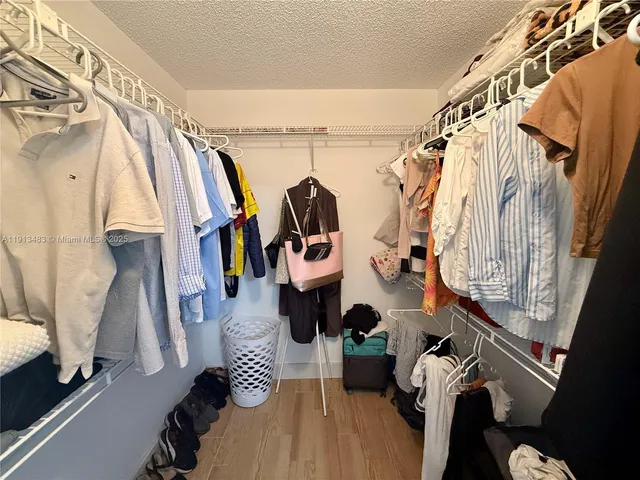 a view of walk in closet with clothes and shoes