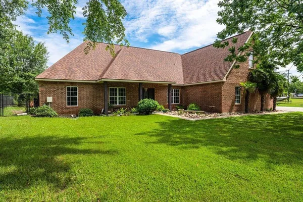 a front view of a house with a yard and green space