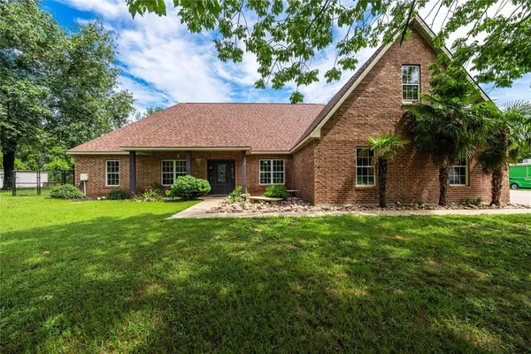 a front view of a house with yard patio and green space