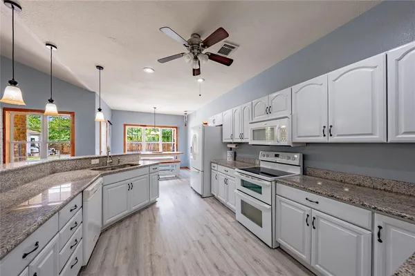 a large kitchen with stainless steel appliances granite countertop a stove and a sink